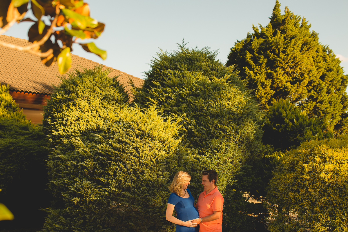 Ensaio gestante da Mariana e Zé com Gustavo Sousa fotografia em Curitiba. Book em externa. Blusa preta e saia. Foto feita no quinto da casa com vestido Azul