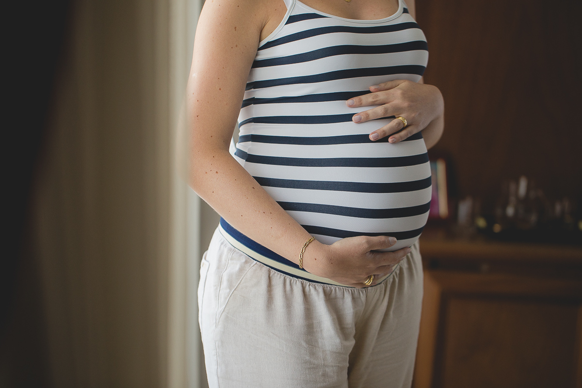 Ensaio gestante da Mariana e Zé com Gustavo Sousa fotografia em Curitiba. Book em externa. Blusa Listrada. Pose na janela 