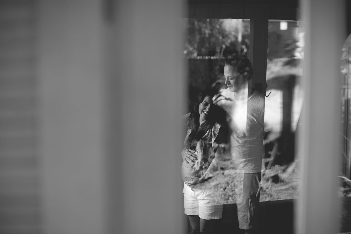 ensaio gestante em externa feito em curitiba com Gustavo Sousa Fotografia. Foto com relexo na janela. 