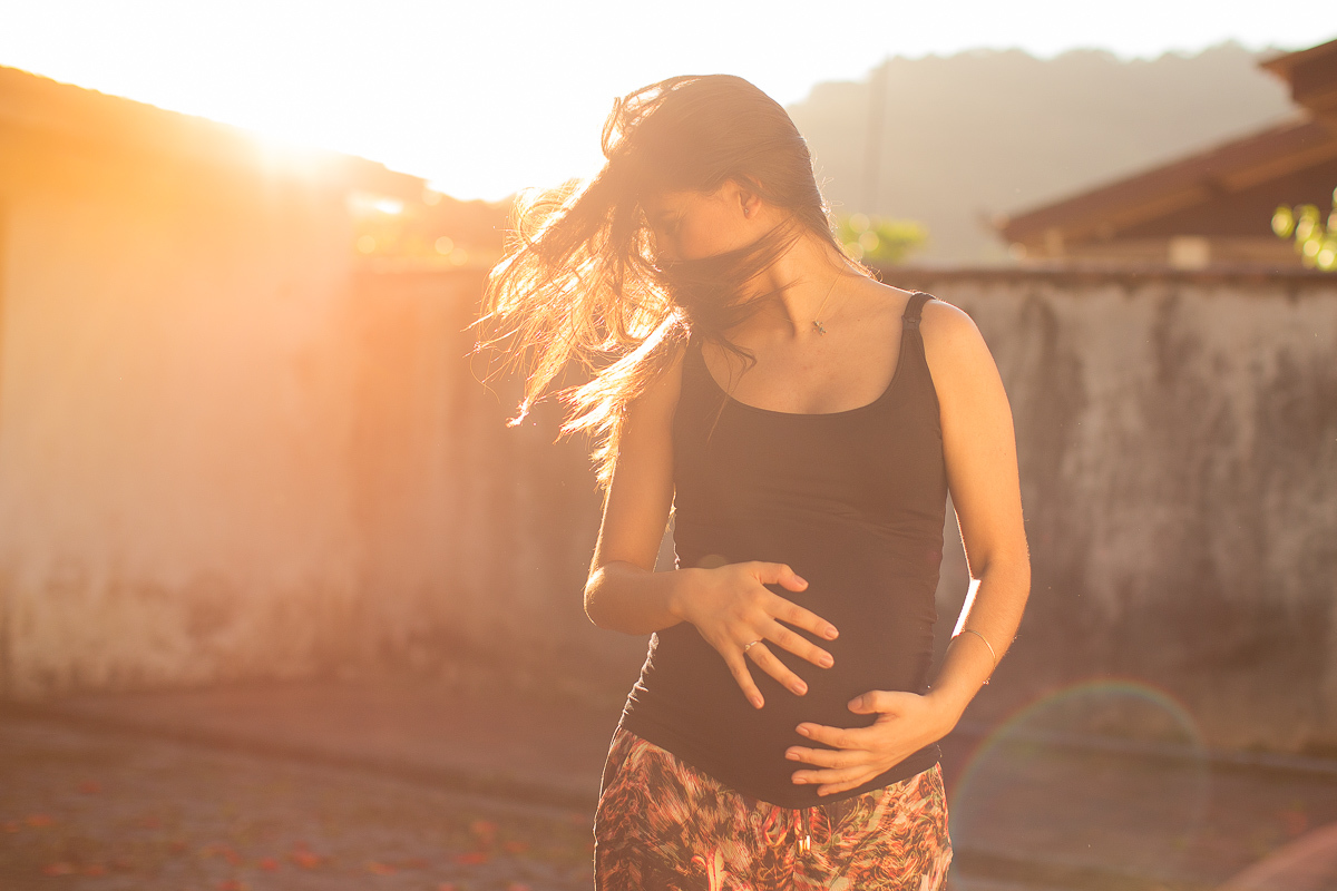 ensaio gestante em externa feito em curitiba com Gustavo Sousa Fotografia. Gestante em pose natural com por do sol