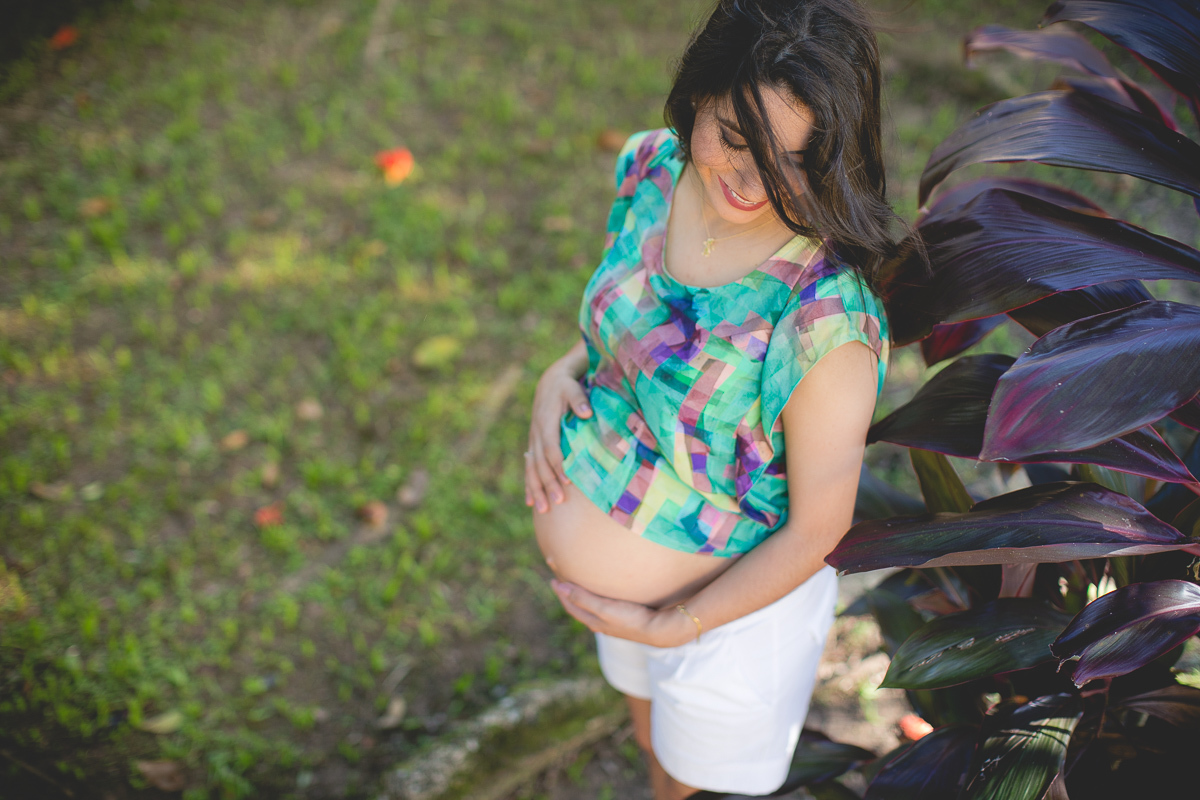 ensaio gestante em externa feito em curitiba com Gustavo Sousa Fotografia. Blusa colorida verde e lilás. Bermuda branca curta. 