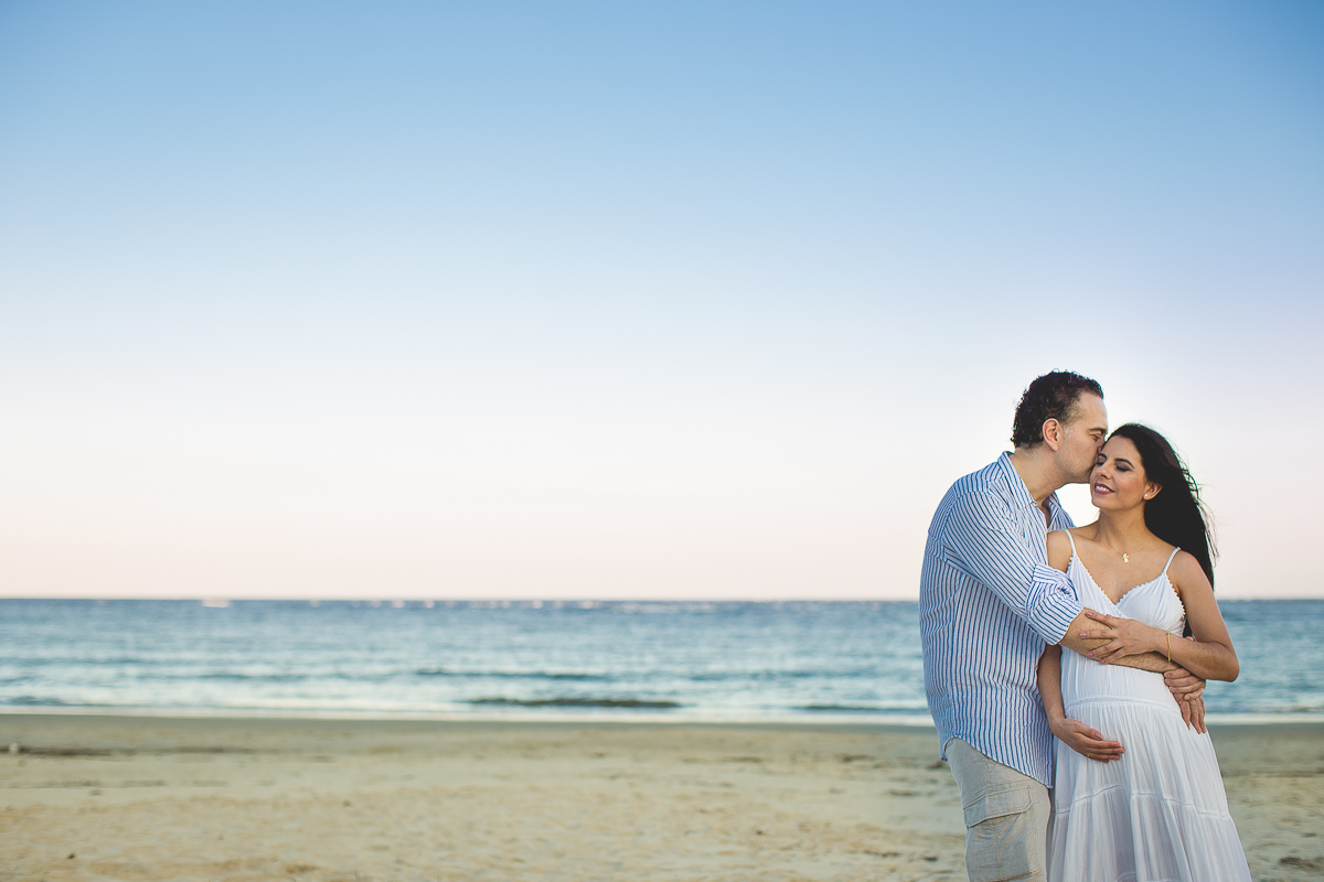 ensaio gestante em externa feito em curitiba com Gustavo Sousa Fotografia. Foto na praia. por do sol. Abraçados