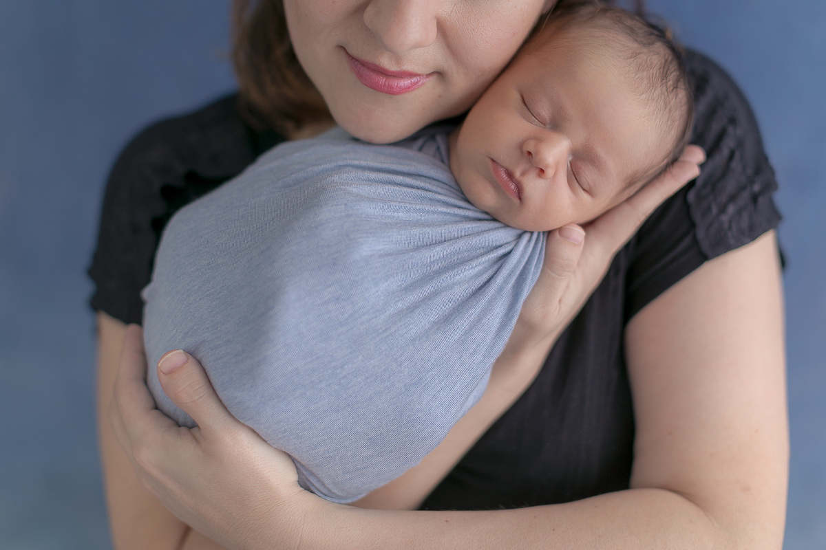 Foto feita no estúdio Gustavo Sousa Newborn em Curitiba. Fotografia com a mãe. Fundo azul. 