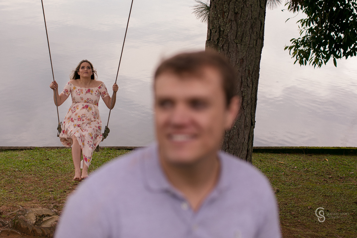 Ensaio gestante da Paty e Jo no estúdio Gustavo Sousa fotografia em Curitiba. Book em externa. Vestido florido Local Laggus Residencial Náutico Mãos na barriga . Gustavo Sousa Fotografia. No balanço Jonatas na frente