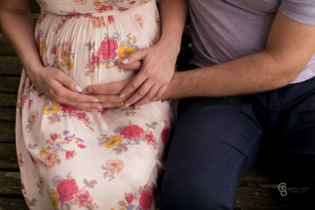 Ensaio gestante da Paty e Jo no estúdio Gustavo Sousa fotografia em Curitiba. Book em externa. Vestido florido. Com marido. Mãos na barriga. Local Laggus Residencial Náutico