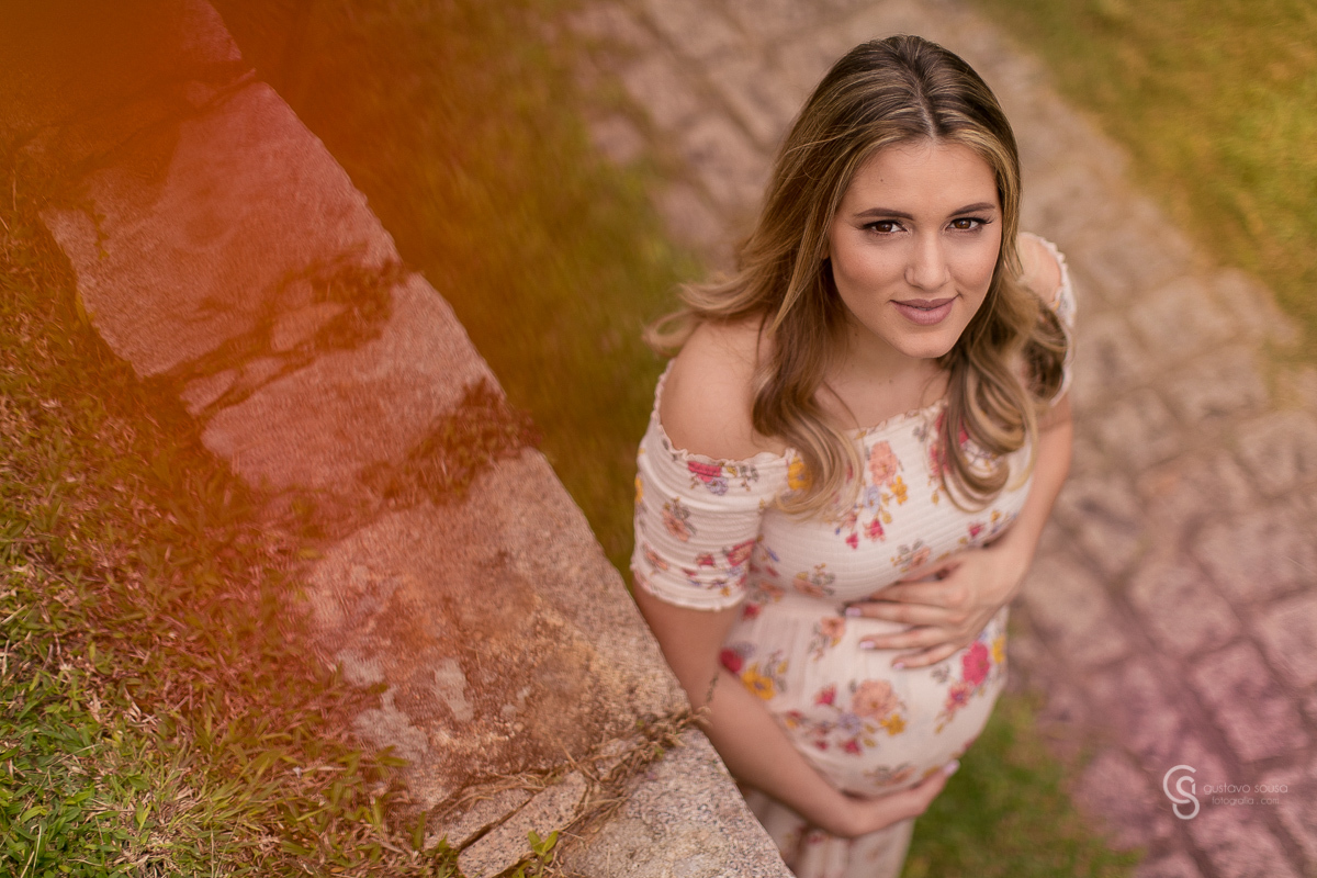 Ensaio gestante da Paty e Jo no estúdio Gustavo Sousa fotografia em Curitiba. Book em externa. Vestido florido Local Laggus Residencial Náutico Mãos na barriga . Gustavo Sousa Fotografia. ângulo de cima.