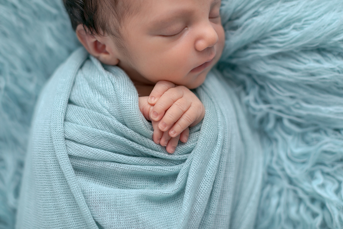 Ensaio Newborn do Leonardo feito nos estúdio Gustavo Sousa fotografia em Curitiba.  Foto feita cheia de amor, segurança e carinho. Fundo de pelo azul enrolado no paninho. Sono suave. Produção Clean.