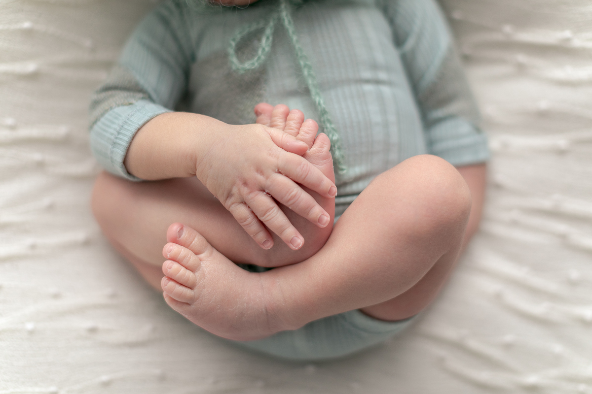 Ensaio Newborn do Leonardo feito nos estúdio Gustavo Sousa fotografia em Curitiba.  Foto feita cheia de amor, segurança e carinho. Pe de barriguinha para cima. Detalhes das mãos e pés. . 
