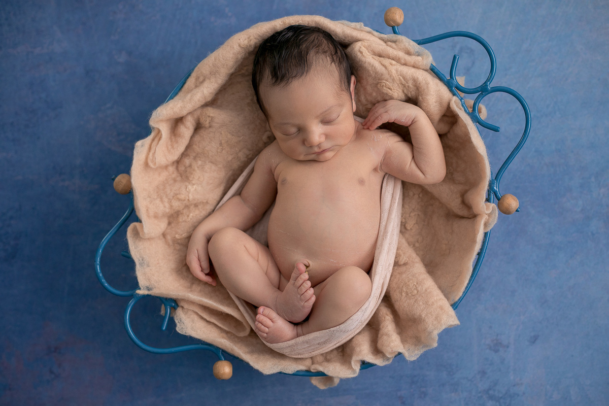 Ensaio Newborn do Leonardo feito nos estúdio Gustavo Sousa fotografia em Curitiba.  Foto feita cheia de amor, segurança e carinho. Leonardo se espreguiçando na produção bege e azul.