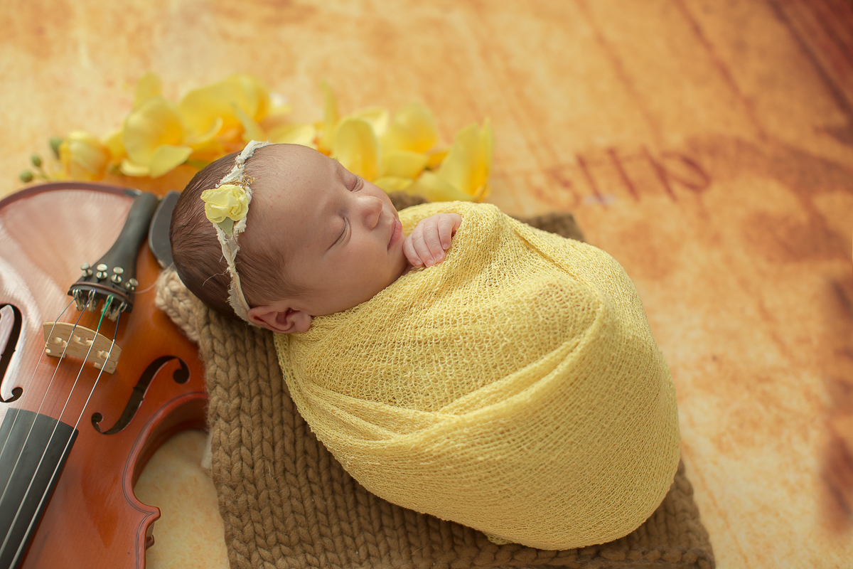 Ensaio newborn em Curitiba. Book feito  em produção cleam. Gustavo Sousa e Kátia Hille. Pose Básica. Fundo rosa. Manta Pipoca, roupa bege. Fundo de madeira. Pose de barriga para cima. Produção de musica com violino. Fundo fotográfico com flores.