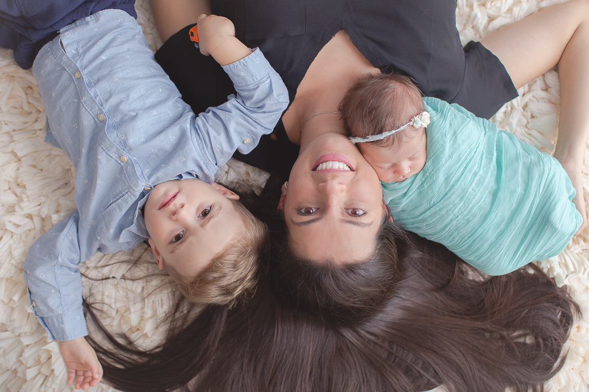 Ensaio newborn em Curitiba. Book feito  em produção cleam. Gustavo Sousa e Kátia Hille. Paleta de tons bege. tecido azul, foto com a mãe, irmão e bebê