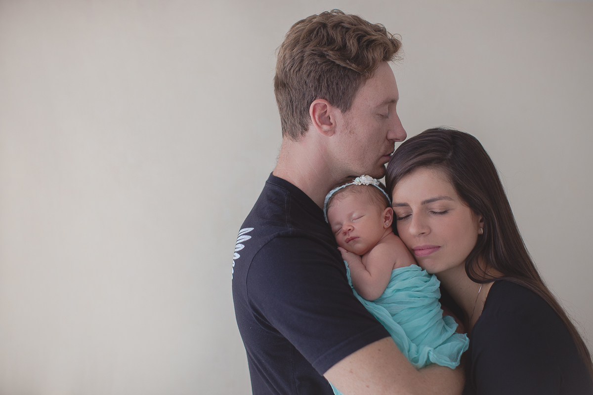 Ensaio newborn em Curitiba. Book feito  em produção cleam. Gustavo Sousa e Kátia Hille. Paleta de tons bege. tecido azul, foto com a mãe, irmão e marido