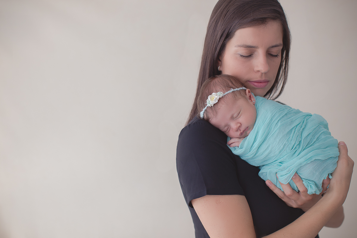 Ensaio newborn em Curitiba. Book feito  em produção cleam. Gustavo Sousa e Kátia Hille. Paleta de tons bege. tecido azul, foto com a mãe,