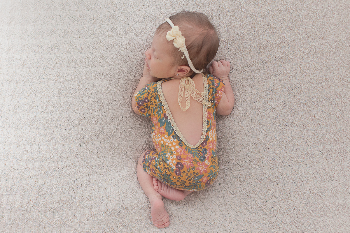 Ensaio newborn em Curitiba. Book feito  em produção cleam. Gustavo Sousa e Kátia Hille. Paleta de tons bege. Roupinha florida pose basica de cima