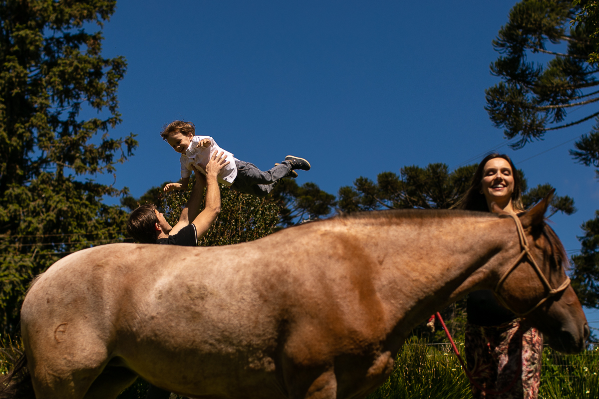 Gustavo Sousa fotografia em ensaio família e gestante na fazenda e haras perto de Curitiba. Brincando com o cavalo 