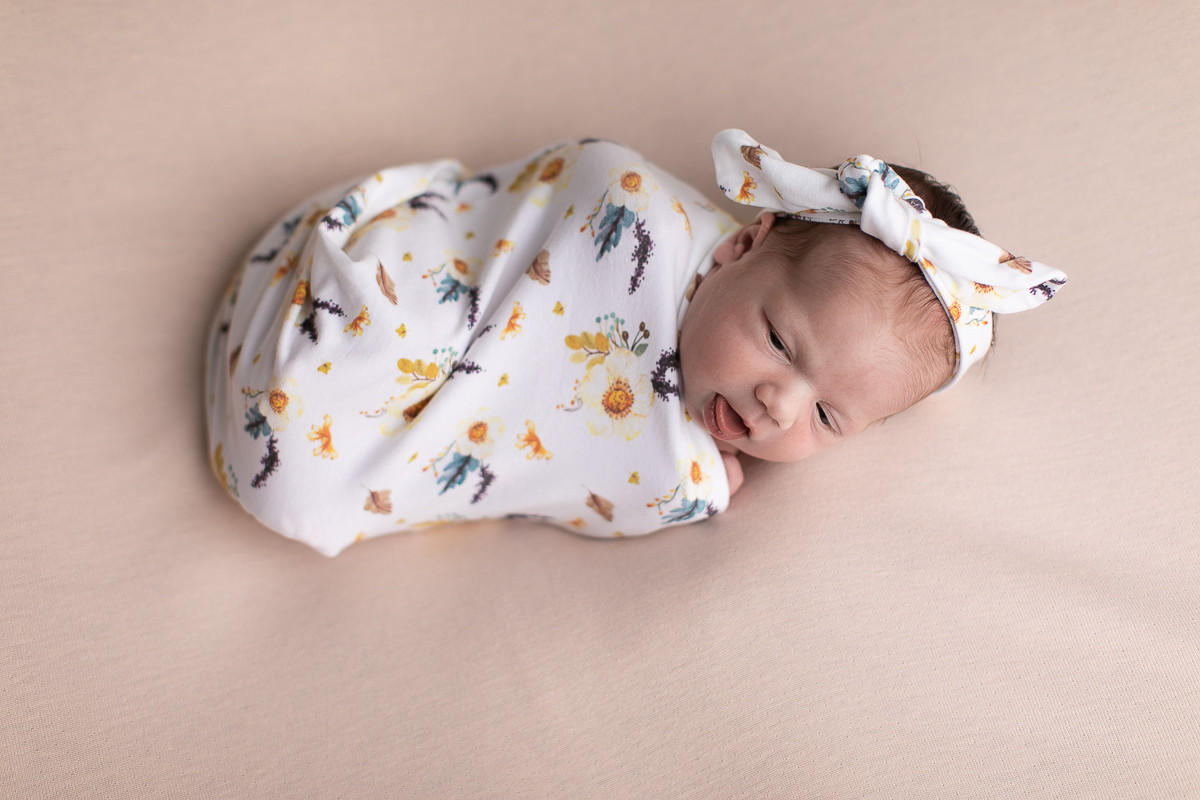 Ensaio newborn da sophia no estúdio gustavo sousa fotografia em curitiba produção simples e clean bebe tranqüilo e calmo. Tecido estampado cor predominante bege  com lacinho do mesmo tecido. Bebê com olho aberto. A 