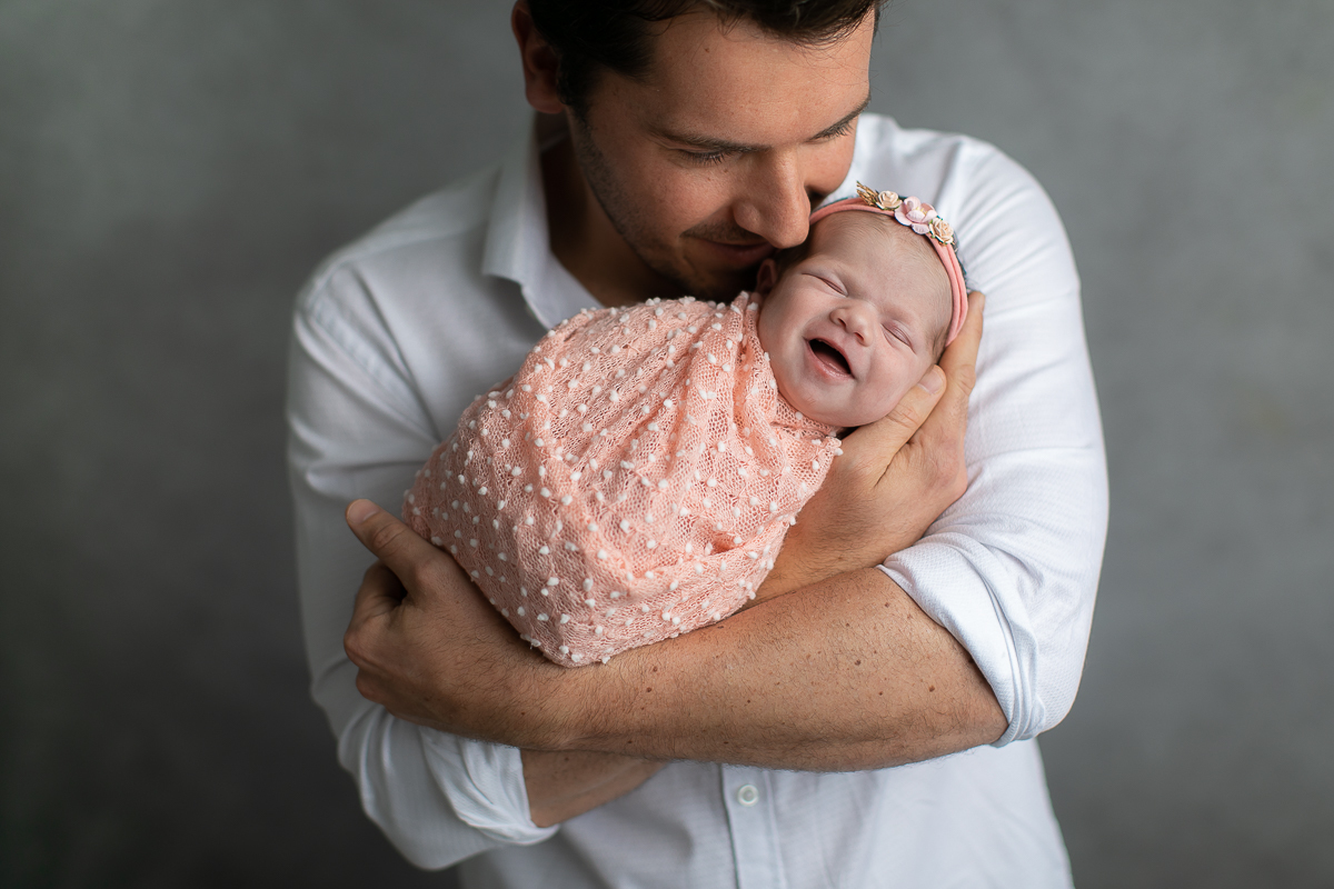 Ensaio newborn da sophia no estúdio gustavo sousa fotografia em curitiba produção simples e clean.  Foto com o papai.  Bebê enroladinho no wrap tecido com textura. 