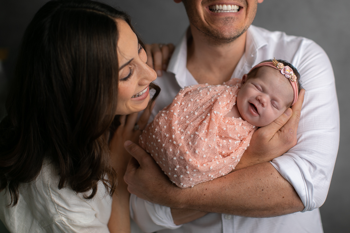Ensaio newborn da sophia no estúdio gustavo sousa fotografia em curitiba produção simples e clean.  Foto com os pais. Bebê enroladinho no wrap tecido com textura. 