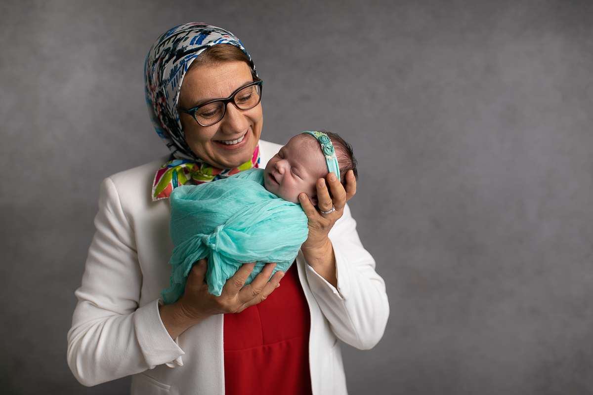 Ensaio newborn da sophia no estúdio gustavo sousa fotografia em curitiba produção simples e clean.  Foto com a vovó. 
 Bebê enroladinho no wrap tecido com textura. 