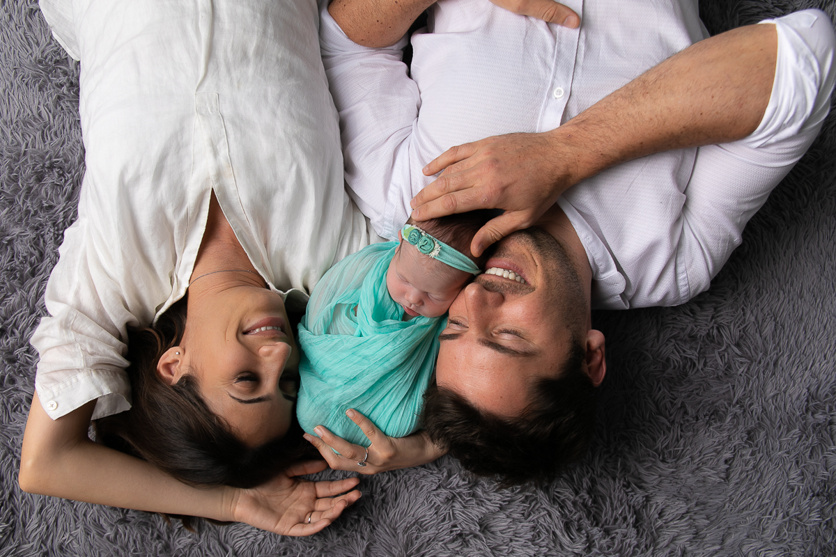 Ensaio newborn da sophia no estúdio gustavo sousa fotografia em curitiba produção simples e clean.  Foto com o papai  e com a mamãe. 
 Bebê enroladinho no wrap tecido com textura verde. 

