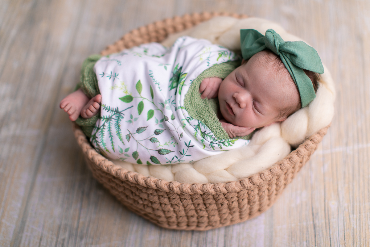 Ensaio newborn da sophia no estúdio gustavo sousa fotografia em curitiba produção simples e clean.  Cesto prop utilizado na produção com lã  merino. Mãos para fora do tecido wrap. Tecido estampado com lacinho no cabelo. 
