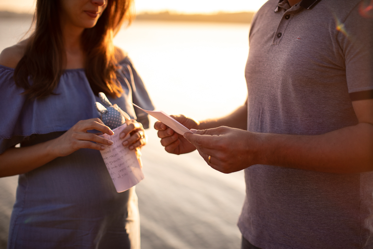 fotografia ensaio gestante no por do sol feita pelo gustavo sousa. No Laggus ensaio e book gestante feita por Gustavo Sousa fotografia em Curitiba. Casal Juntos no trapiche do lago Residencia Laggus. Lendo carta. Emocionante. 