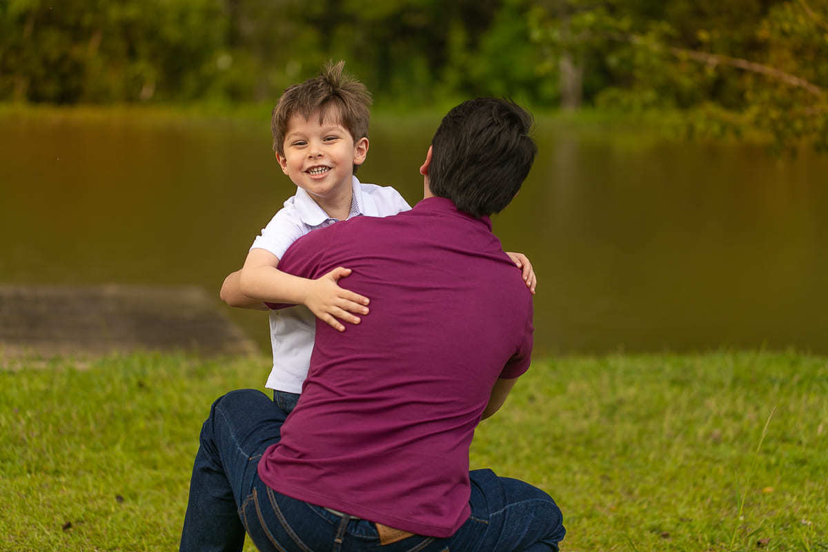 gustavo sousa fotografa na chácara Mangala em Curitiba. Fotos espontâneas. Ensaio gestante e família. Pai e filho se abraçam