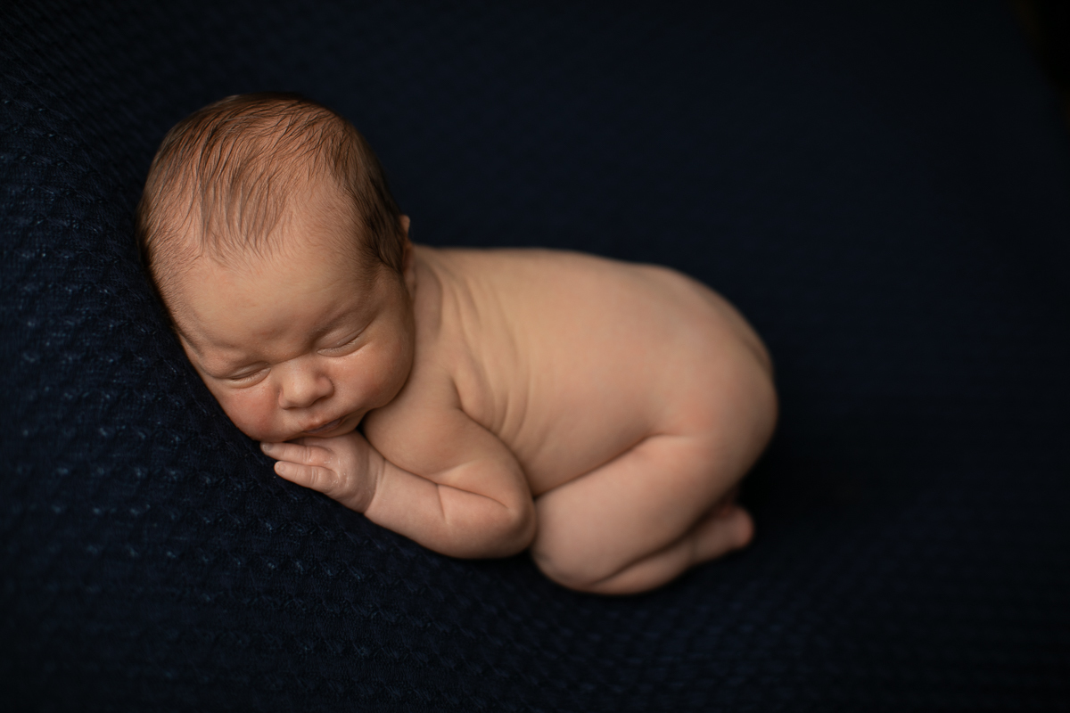 gustavo sousa fotografia faz ensaios e books de gestante e newborn em Curitiba e região. O Otávio foi fotografado em plena segurança e conforto. Muito amor foi dado aqui. Foto no puffe azul escuro.