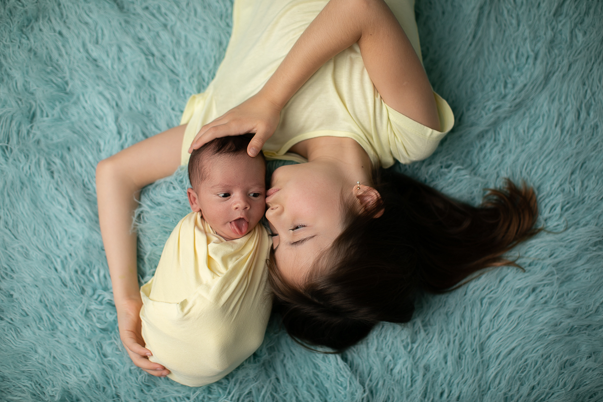 gustavo sousa fotografia ensaio newborn curitiba. Com a irmã em fundo azul. Roupas amarelas.  Newborn Mostrando a Língua.