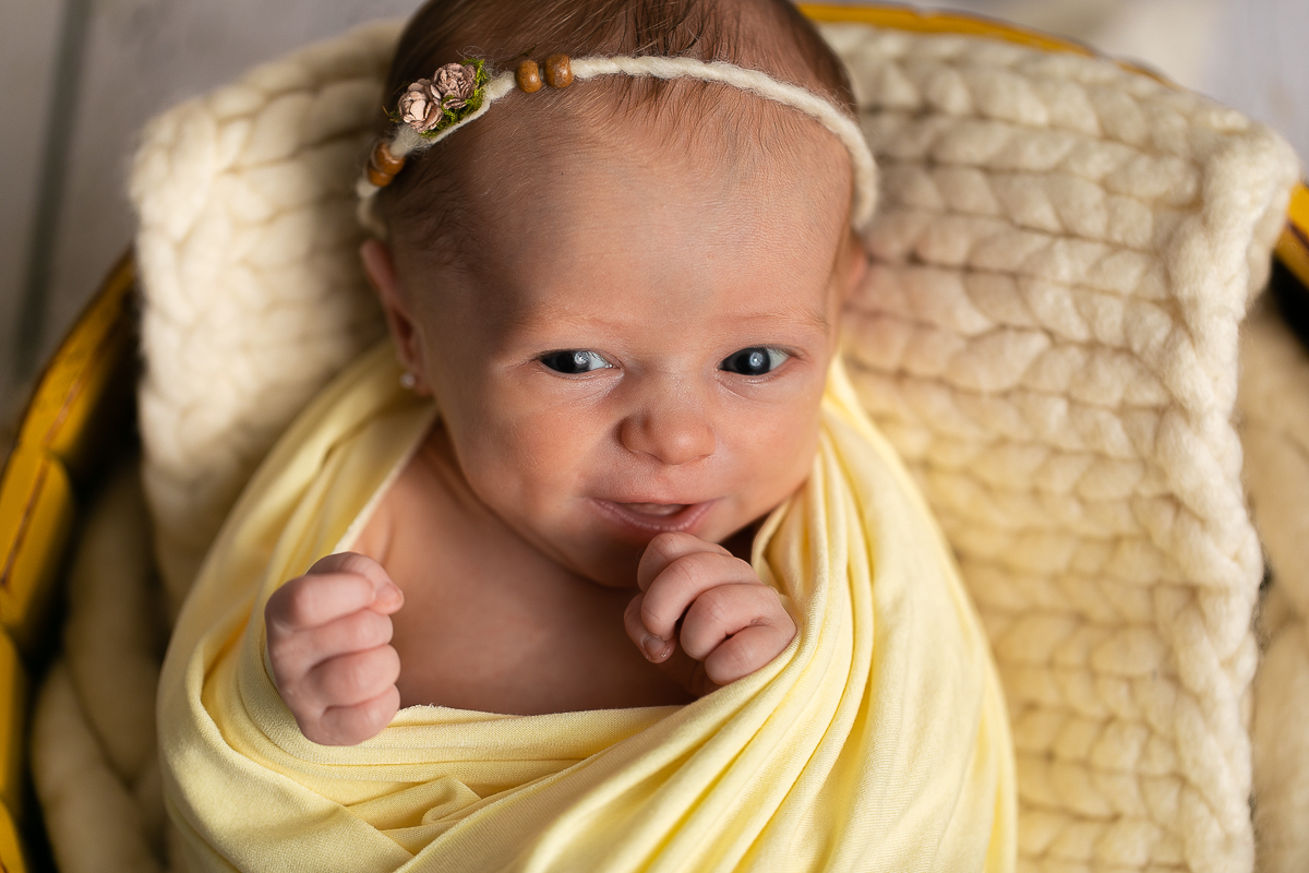 Sousa Fotografia em Curitiba. Foto de bebê enrolada em wrap bocejando