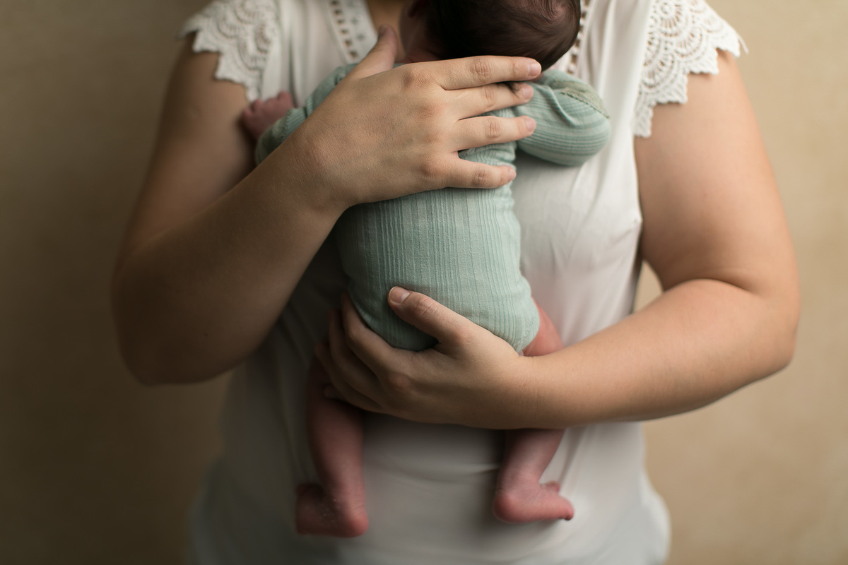 Ensaio Newborn Gustavo Sousa Fotografia em Maringá. Segurando o bebê