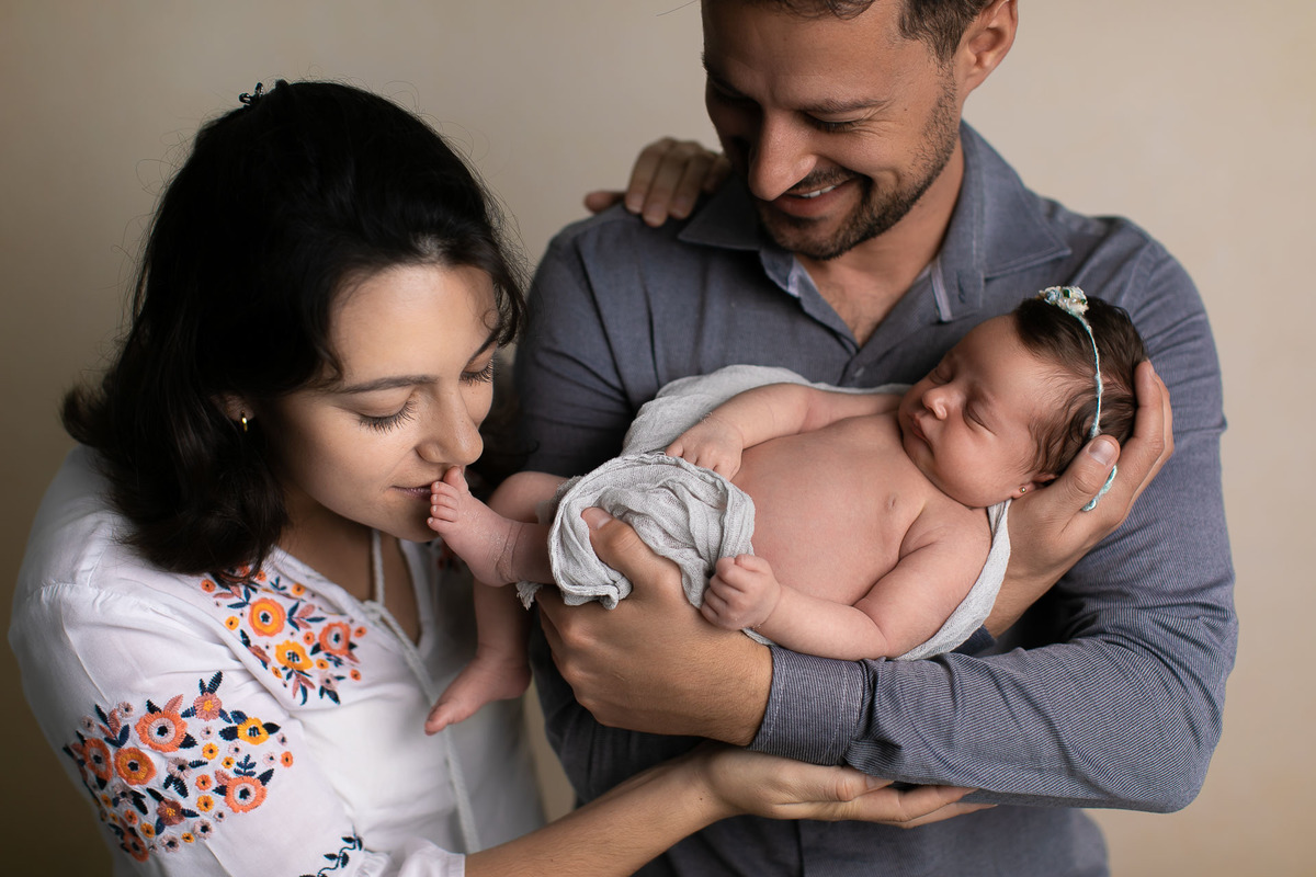 Gustavo Sousa fotografia. Atendemos em Maringá book e ensaio gestante, família e newborn. Amamos tudo isso. Família segurando o newborn
