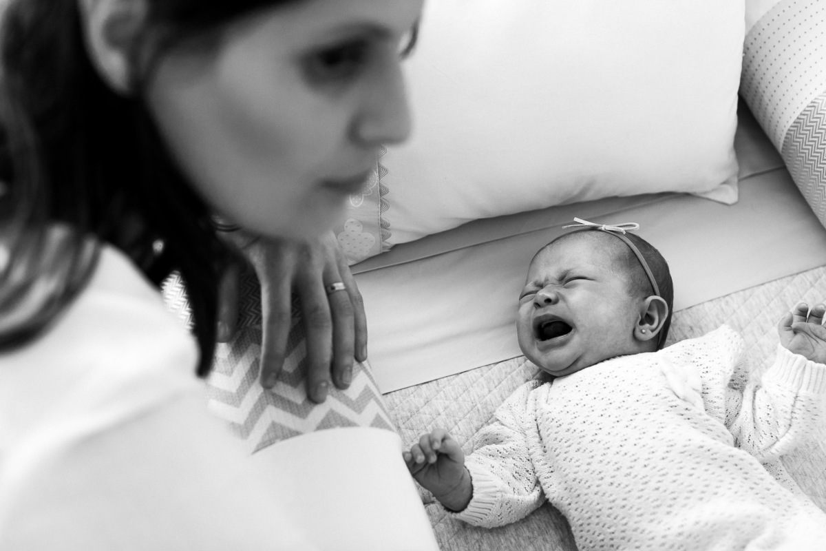 Gustavo Sousa estúdio de fotografia em Maringá-PR. Ensaio e book fotográfico newborn lifestyle e família. Foto de mãe com bebê chorando.