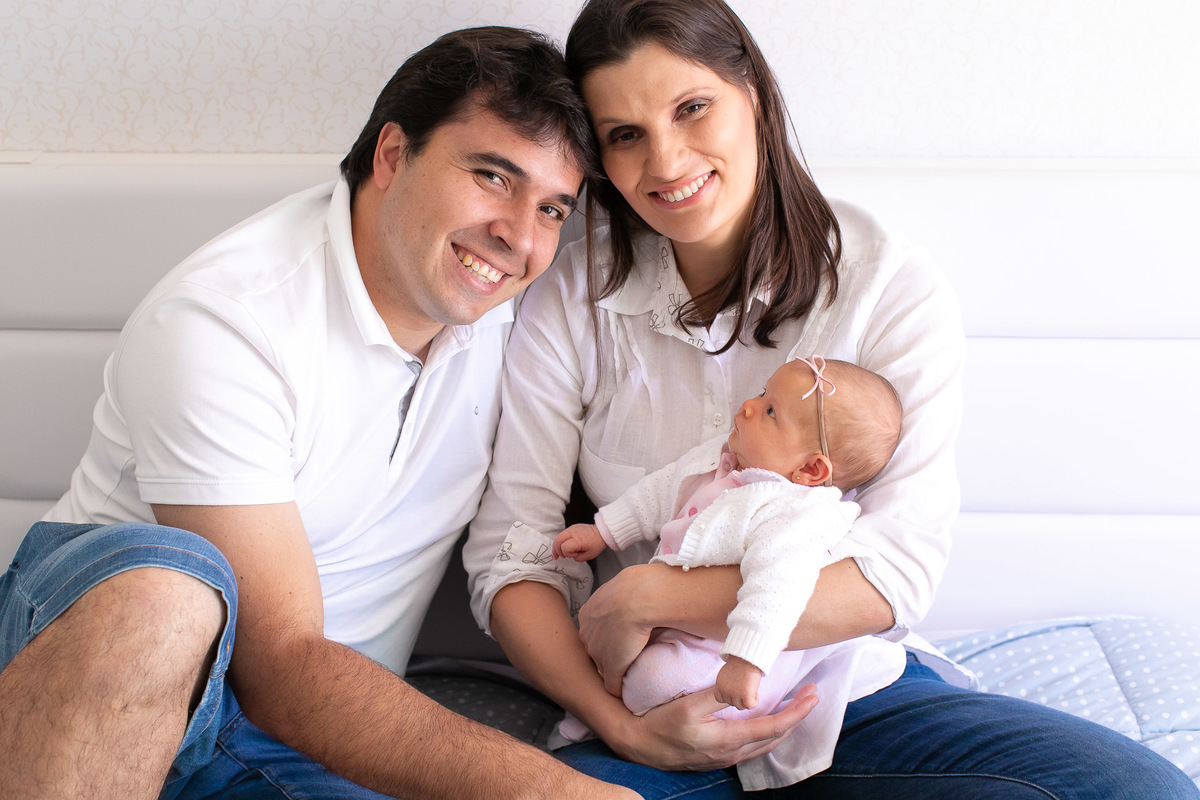 Gustavo Sousa estúdio de fotografia em Maringá-PR. Ensaio e book fotográfico newborn lifestyle e família. Foto em família, mãe com bebê no colo, pai e mãe sorrindo.