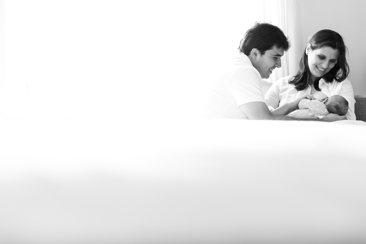 Gustavo Sousa estúdio de fotografia em Maringá-PR. Ensaio e book fotográfico newborn lifestyle e família. Foto em preto e branco de família, mãe  amamentando bebê.