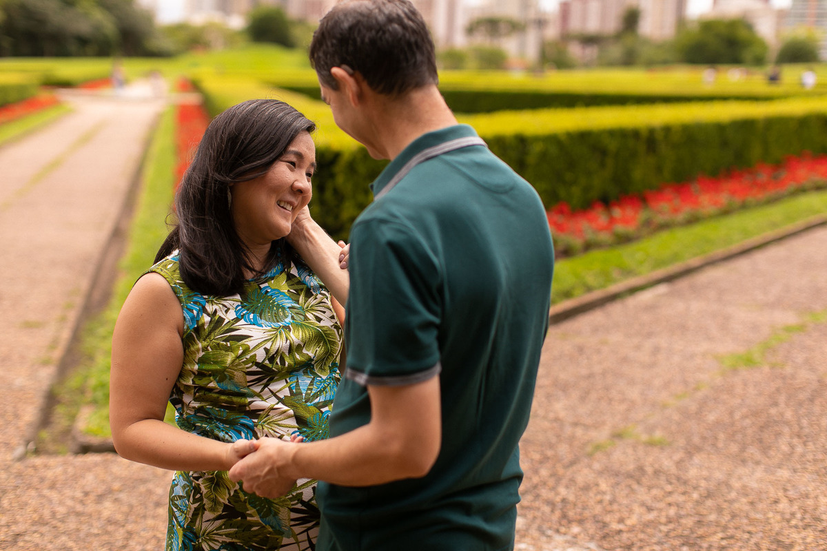Gustavo Sousa estúdio de fotografia em Maringá-PR. Ensaio e book fotográfico gestante. Foto de casal, homem fazendo carinho no rosto da esposa gestante.