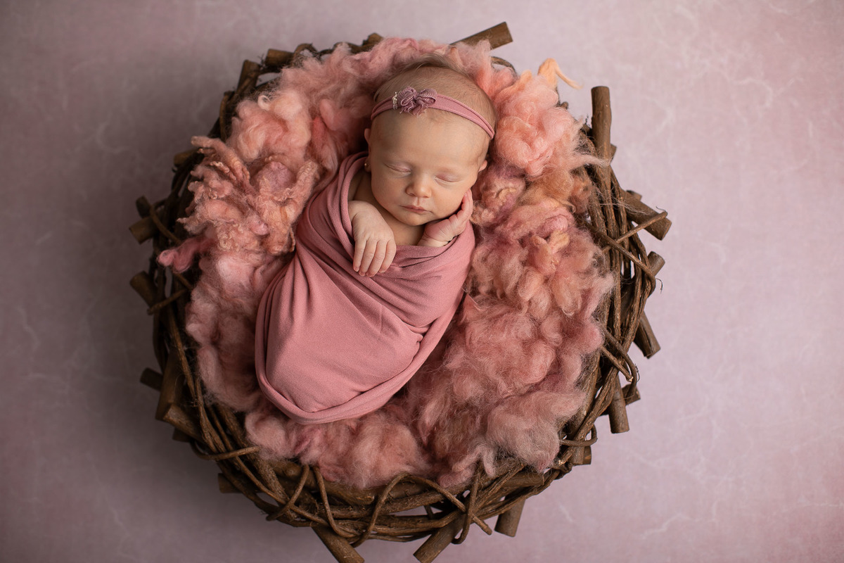 Gustavo Sousa estúdio de fotografia em Maringá-PR. Ensaio e book fotográfico newborn.  Foto bebê recém nascida em cesto enrolada em wrap rosa
