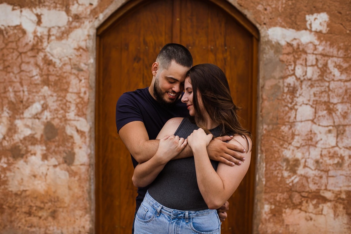 Capela Sagrada Família - Ruínas - em Mandaguari, região de Maringá. Casal vestidos de preto em frente a porta da igreja. Foto por Gustavo Sousa Fotografia. Casal vestido de preto na porta da igreja
