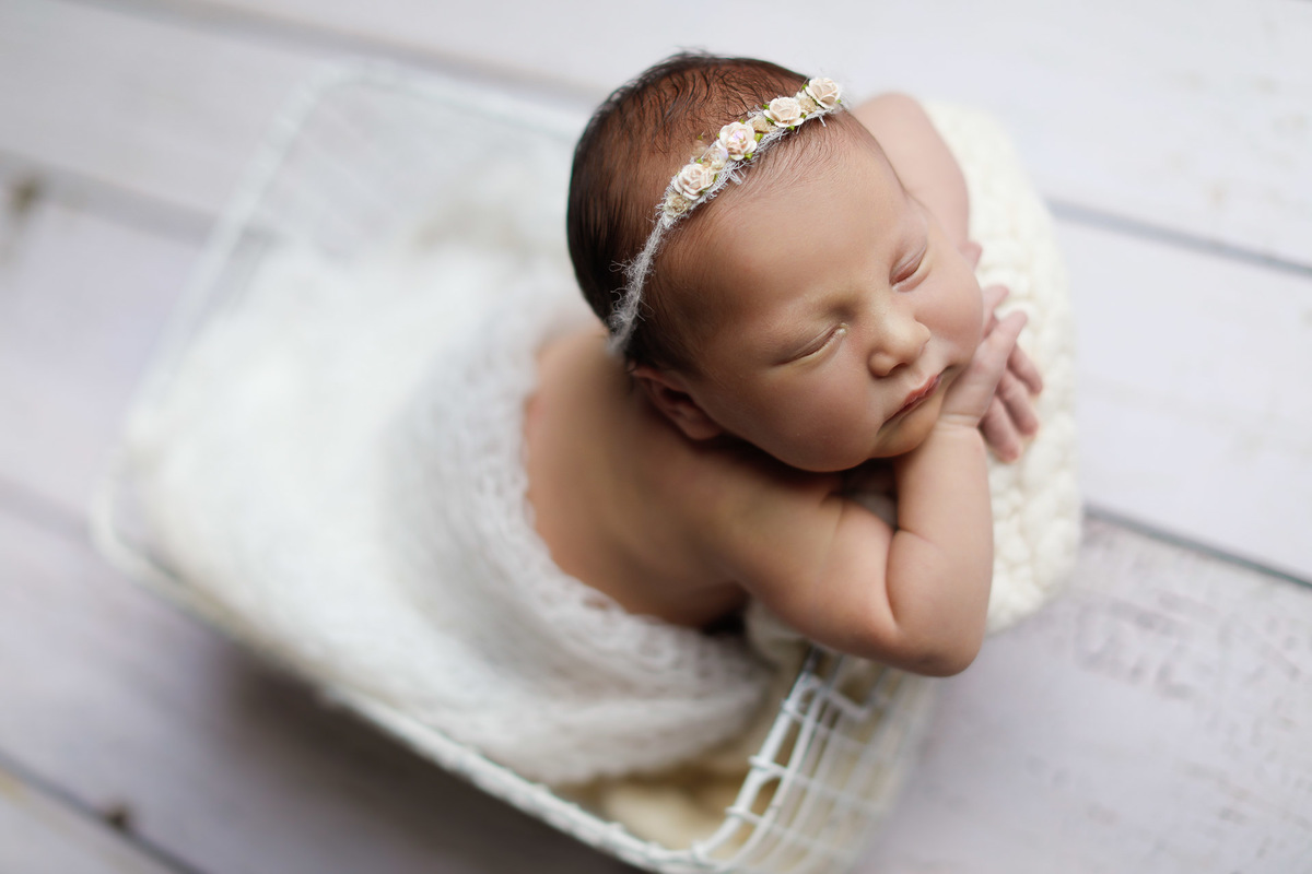 Gustavo Sousa fotografia ensaio de recém-nascido newborn em Maringá. Pose do bracinho em prop de arema e fundo de madeira claro