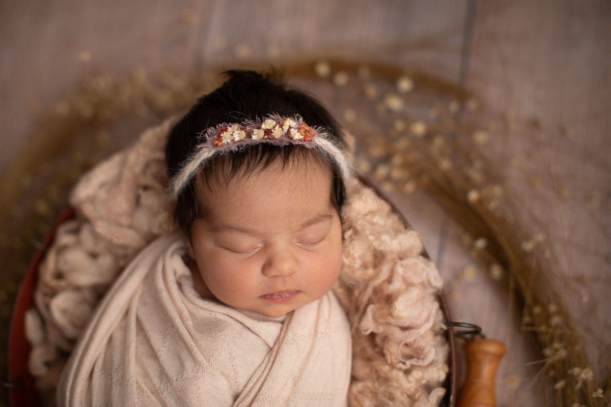 gustavo sousa fotografia em maringá estúdio de newborn e recém-nascidos. Bebê em prop rústico. Paleta de cor beje.