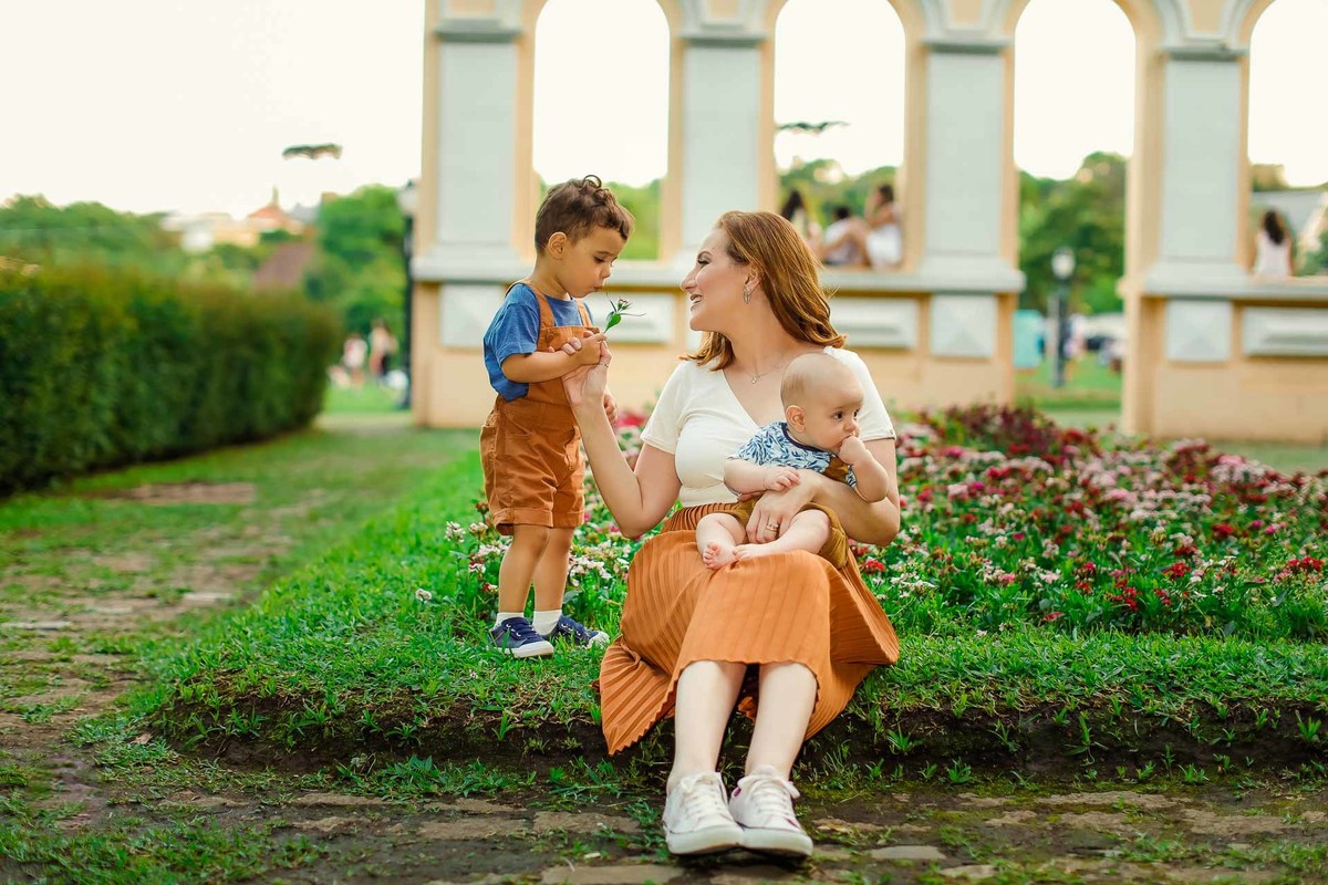 Gustavo Sousa fotografia em Maringá-PR. Ensaio família. Filho dando flor par a mãe. family photoshoot. little son giving his mother a flower
