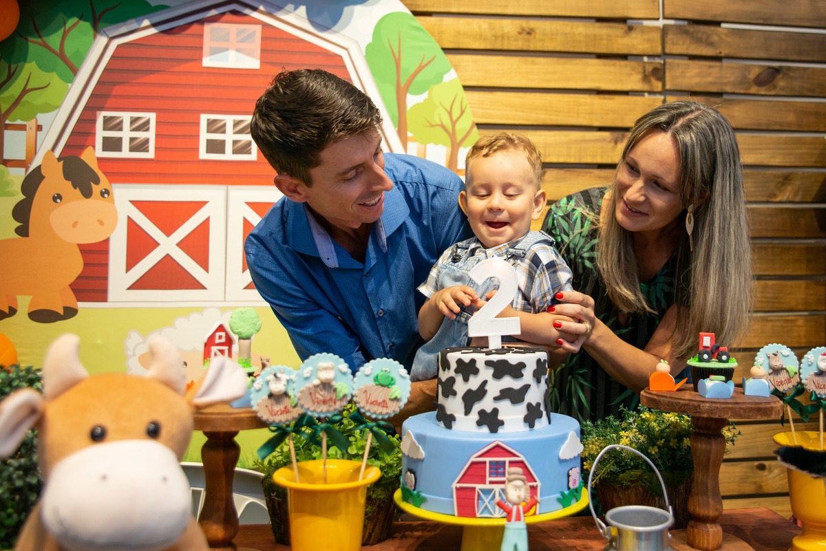 assoprando as velinhas em aniversário de 2 anos em cada de festa infantil com o tema da Fazendinha
