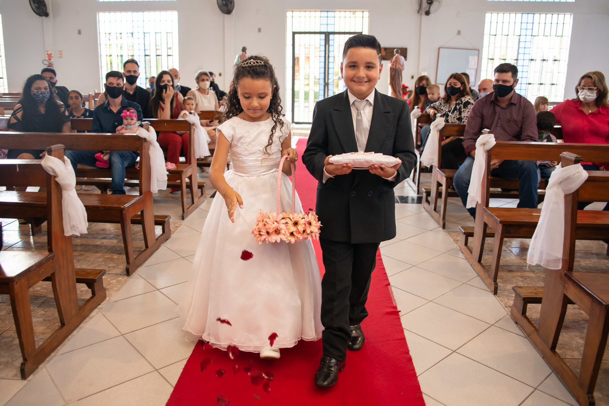 pajem e aia entrando na igreja com as alianças e pétalas de rosas