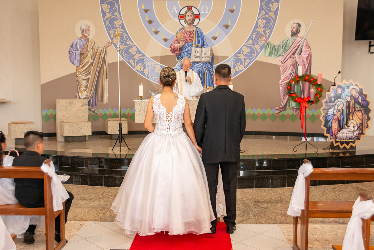 noivos de costas no altar da igreja, padre ao fundo
