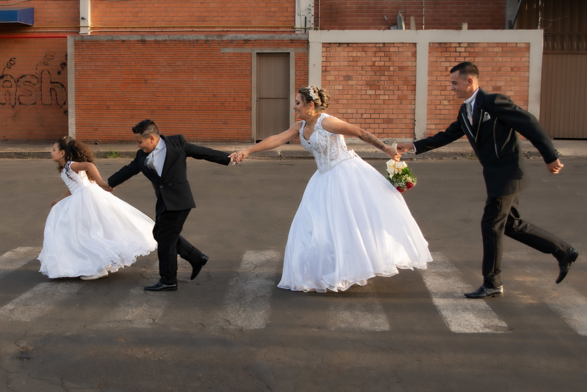 pajem, aia, noiva e noivo correndo no meio da rua