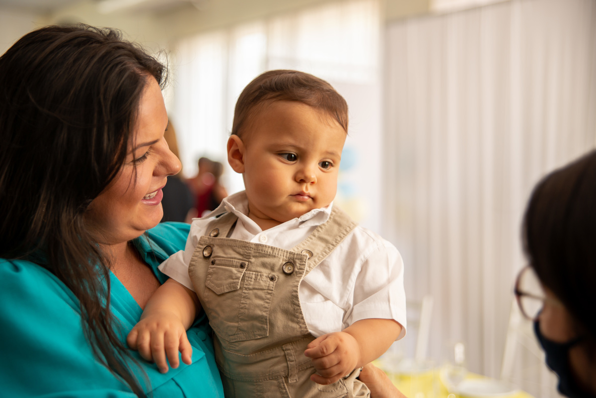 Menino de um ano no colo da mãe