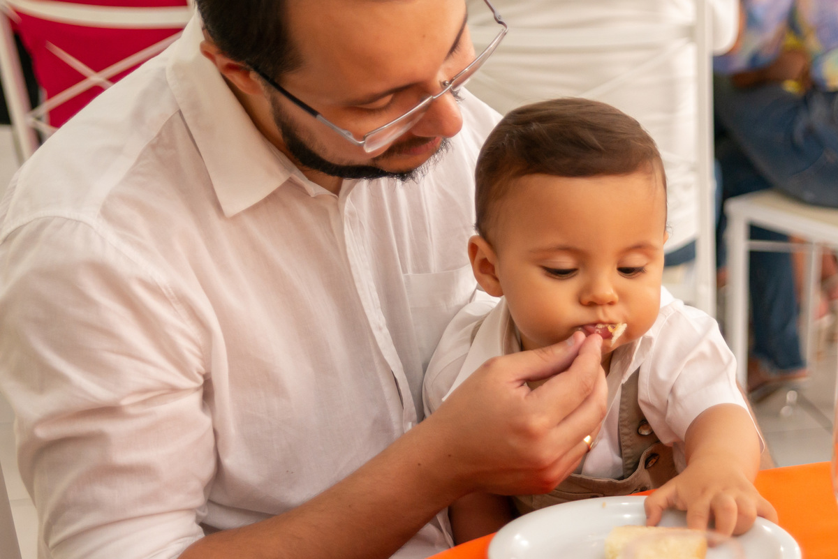 menino de um ano comendo em festa infantil