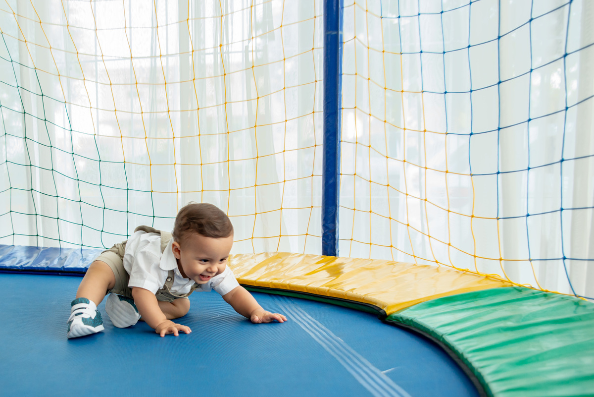 menino de um ano brincando em cama elástica