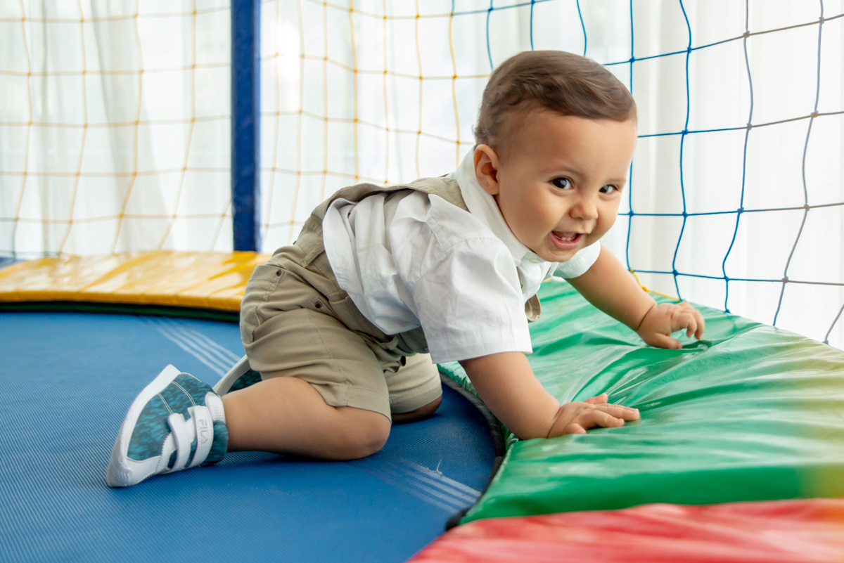 menino de um ano brincando em cama elástica