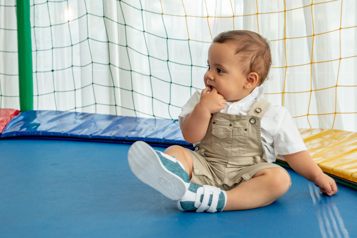 menino de um ano brincando em cama elástica